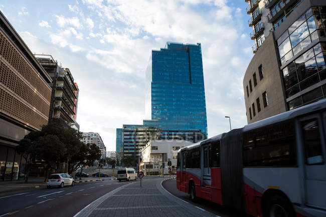 Moderni edifici per uffici in città con strada urbana, auto e autobus — Foto stock