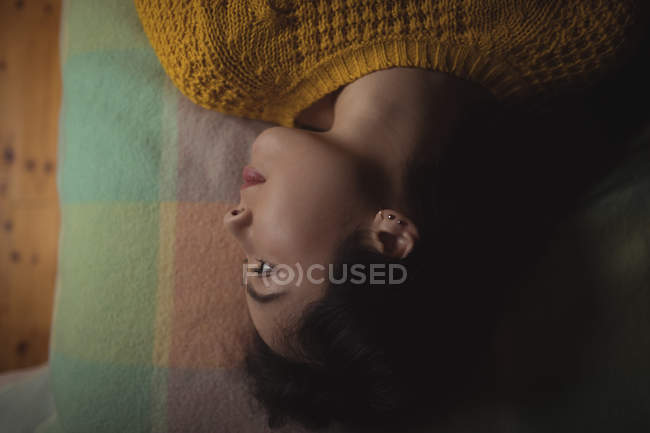 Thoughtful woman lying on bed at home — Stock Photo