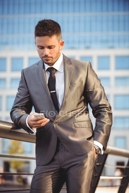 Geschäftsmann benutzte Handy in der Nähe von Bürogebäude — Stockfoto