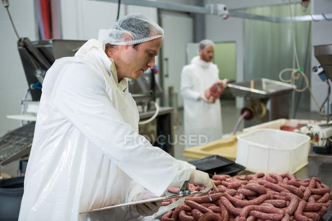 Metzger hält in Fleischfabrik Platten auf Klemmbrett — Stockfoto