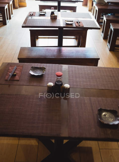 Mesas y bancos de comedor vacíos en el restaurante - foto de stock