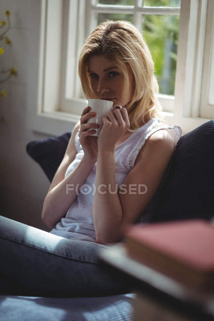 Красива жінка має каву у вітальні вдома — стокове фото