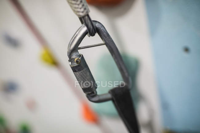 Close-up of carabiner hook on climbing artificial wall in gym — Stock Photo