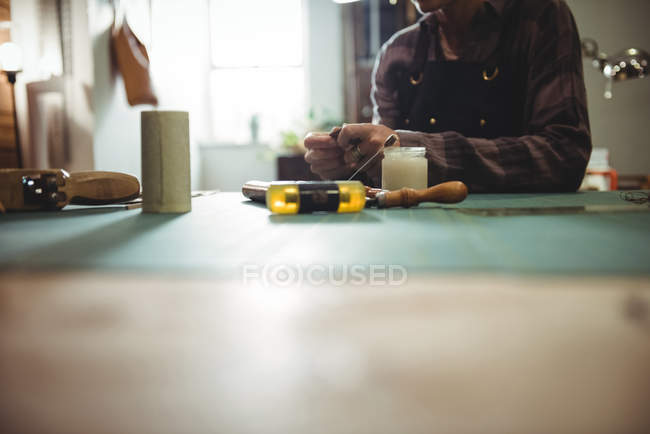 Mid-section of craftswoman preparing leather belt in workshop — Stock Photo