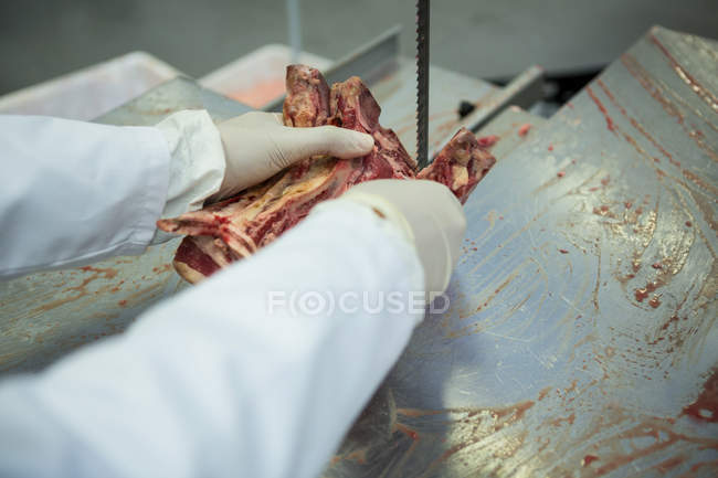 Close-up of butcher cutting meat with meat cutting machine — Stock Photo