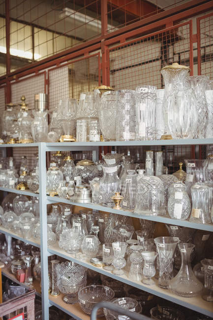 Vetreria vuota sistemata sullo scaffale in officina presso la fabbrica di soffiaggio del vetro — Foto stock