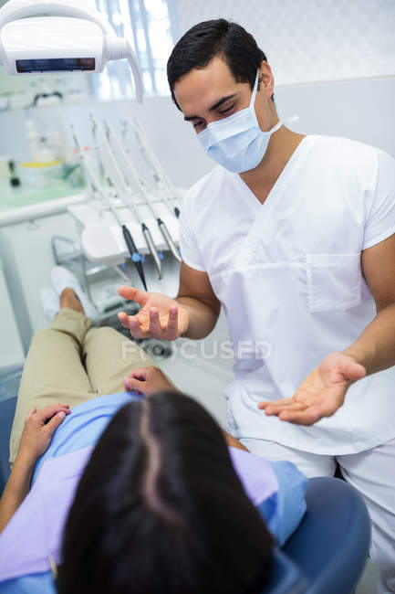 Dentista conversando con la paciente de la clínica - foto de stock