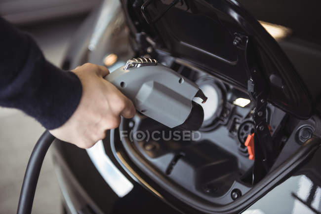 Close-up of man charging car at electric vehicle charging station — Stock Photo
