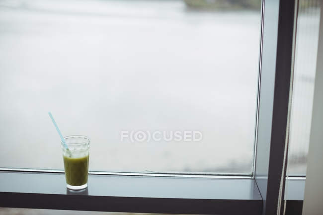 Glass of juice kept on windowsill at home — Stock Photo
