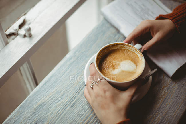 Close-up de mãos femininas segurando xícara de café — Fotografia de Stock