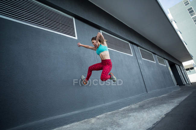 Женщина, практикующая паркур на улице — стоковое фото