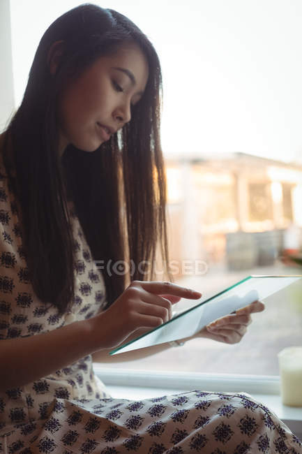 Красива жінка використовує футуристичний цифровий планшет в кафе — стокове фото