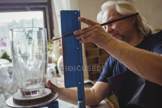 Soplador de vidrio que trabaja en una cristalería en la fábrica de soplado de vidrio - foto de stock