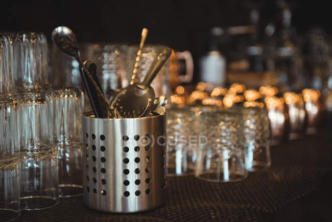 Крупним планом порожні окуляри та барні інструменти, розташовані на полиці в барі — стокове фото