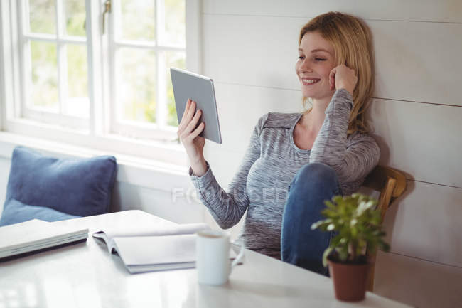 Hermosa mujer usando tableta digital en la sala de estar en casa - foto de stock