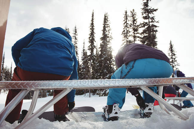 Vista posteriore di coppia seduta su panchina in montagna innevata — Foto stock