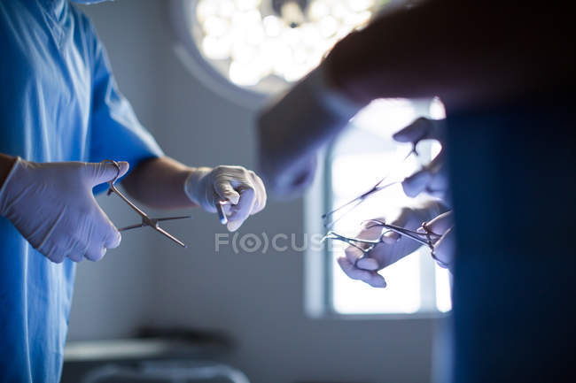 Grupo de cirujanos que realizan operaciones en quirófano del hospital - foto de stock