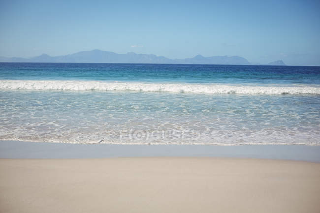 Прекрасный вид на песчаный пляж и спокойный морской пейзаж — стоковое фото