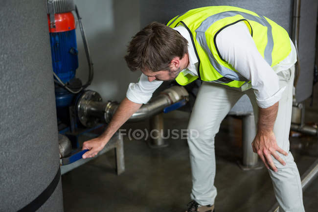 Hochwinkelaufnahme eines männlichen Arbeiters, der Maschinen in Fabrik bedient — Stockfoto