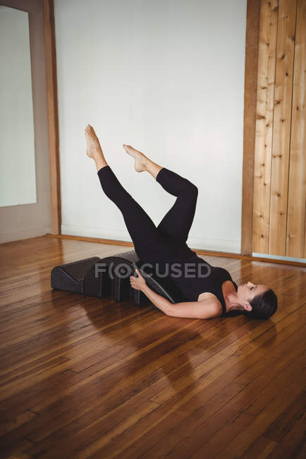Woman exercising with yoga back arch in fitness studio — Stock Photo