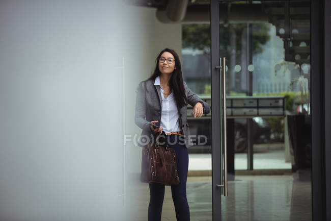 Porträt einer Geschäftsfrau, die am Eingang ihres Büros steht — Stockfoto