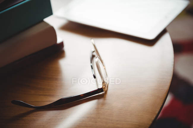 Spectacles and books on wooden table at home — Stock Photo