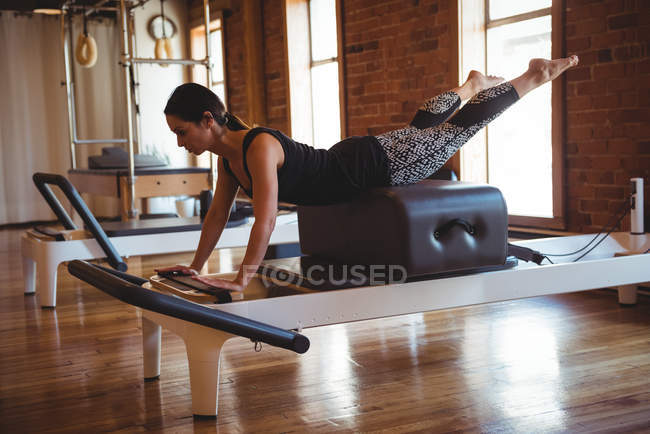 Donna che pratica pilates sul riformatore in palestra — Foto stock