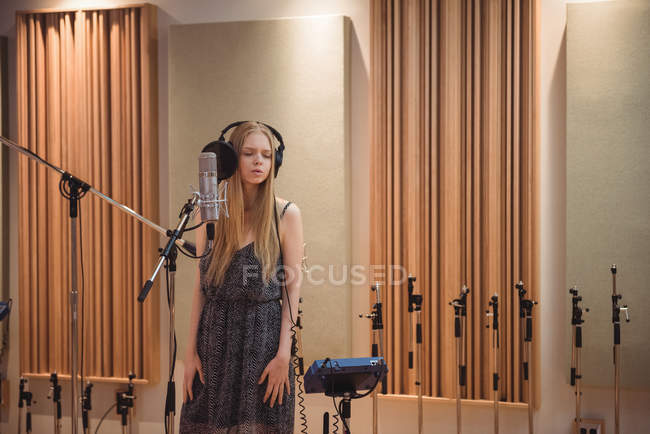 Frau singt im Tonstudio am Mikrofon — Stockfoto