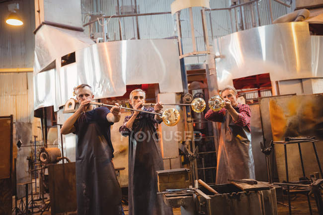 Equipe do ventilador de vidro que dá forma a um vidro no blowpipe na fábrica de sopro de vidro — Fotografia de Stock