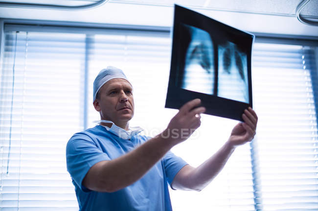 Cirurgião masculino examinando raio-X no hospital — Fotografia de Stock