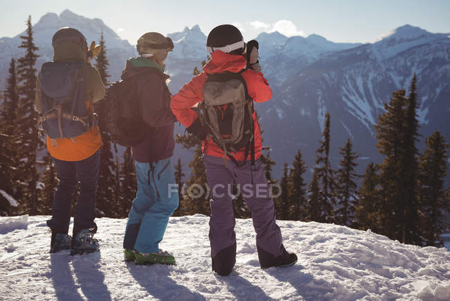 Vista traseira de esquiadores em pé no topo da montanha durante o inverno — Fotografia de Stock