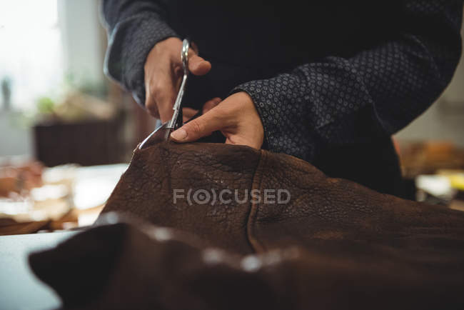 Середньої частини craftswoman різання шкіри в майстерні — стокове фото