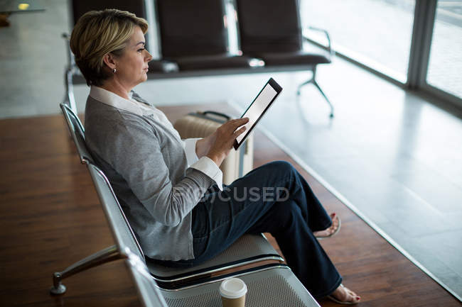 Donna d'affari che utilizza tablet digitale in sala d'attesa presso il terminal dell'aeroporto — Foto stock