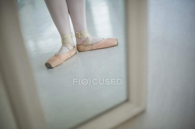 Mirror reflection of ballerina feet wearing ballet shoes in studio — Stock Photo