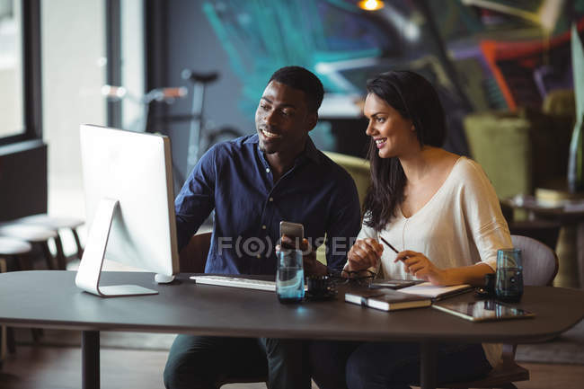 Businessman and a colleague discussing over computer in office — Stock Photo