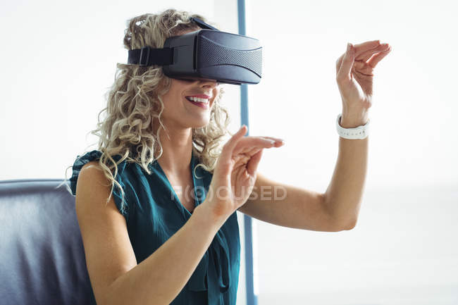 Ejecutivo empresarial que utiliza auriculares de realidad virtual en la oficina - foto de stock