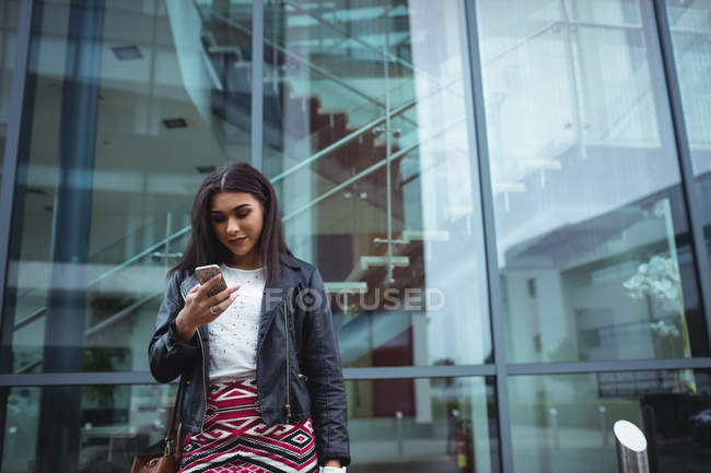 Жінка, використовуючи мобільний телефон за межами Офісна будівля — стокове фото