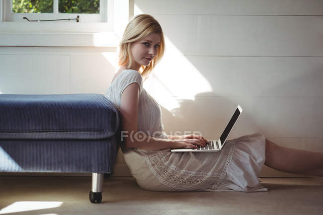 Портрет красивой женщины с помощью ноутбука в гостиной на дому — стоковое фото