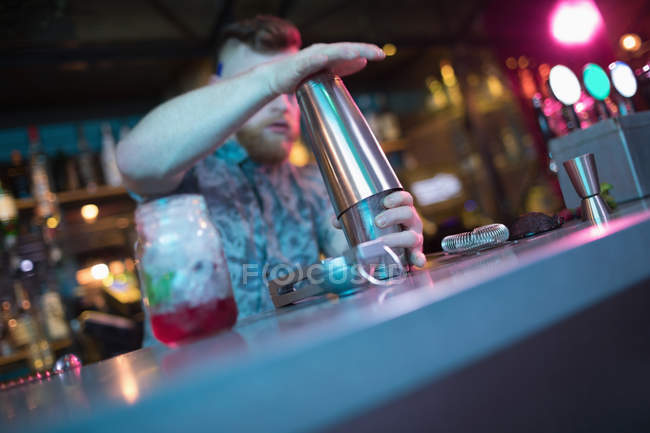 Bartender preparing cocktail at counter in bar — Stock Photo