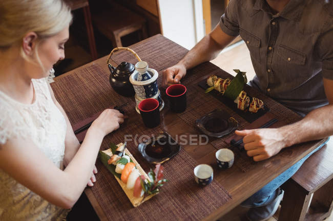 Vista de alto ângulo de casal tendo sushi no restaurante — Fotografia de Stock
