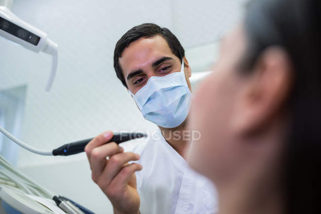 Dentista masculino examinando paciente feminina na clínica — Fotografia de Stock