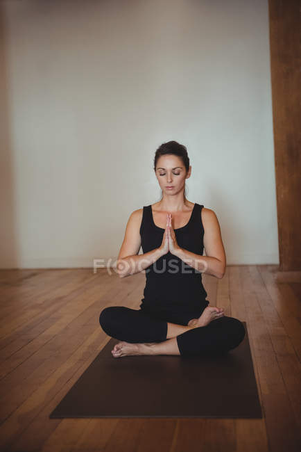 Woman practicing yoga in fitness studio — Stock Photo