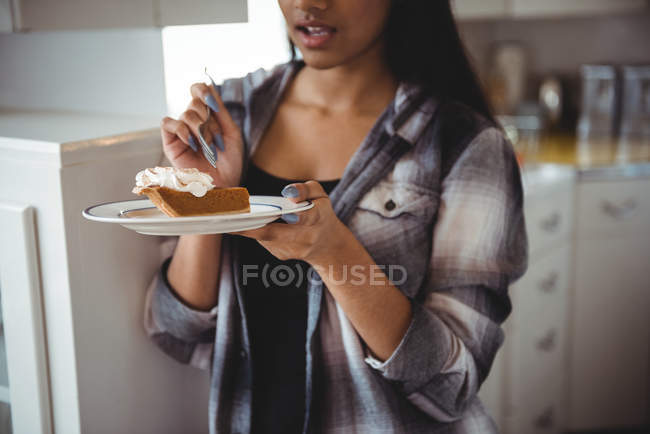 Mid section of woman having breakfast in kitchen at home — Stock Photo