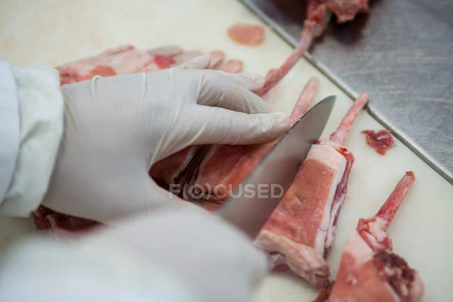 Крупним планом м'ясорубка ріже м'ясо на м'ясному заводі — стокове фото