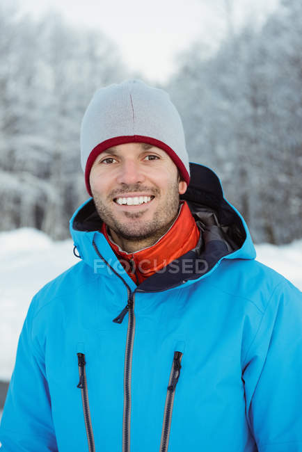 Retrato de homem sorridente em pé na paisagem nevada — Fotografia de Stock
