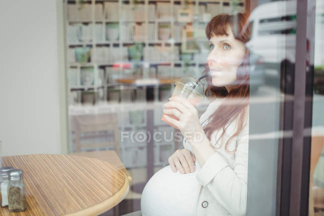 Schwangere Geschäftsfrau trinkt Fruchtsaft in Büro-Cafeteria — Stockfoto