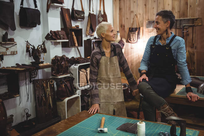 Artesanos sonrientes interactuando entre sí en el taller - foto de stock
