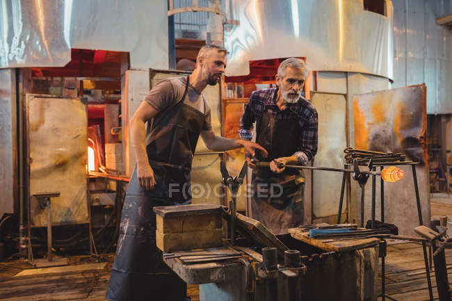 Team of glassblower shaping a molten glass at glassblowing factory — Stock Photo