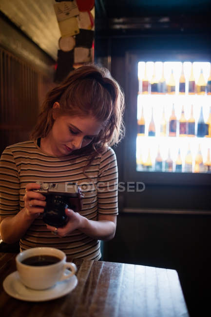 Frau klickt auf ein Bild von Kaffee in der Bar — Stockfoto