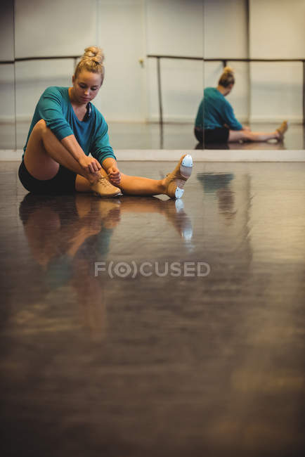 Frau bindet Schnürsenkel im Tanzstudio — Stockfoto